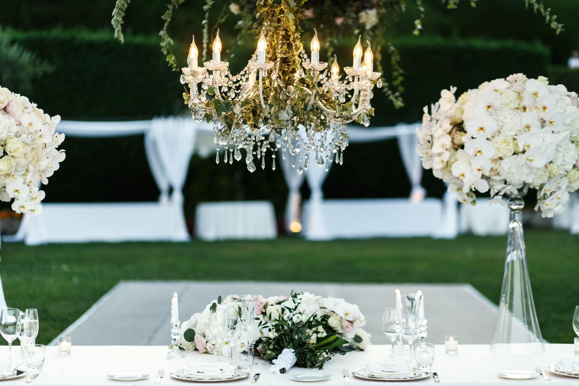 chandelier-with-flowers-greenery-hangs-dinner-table-min